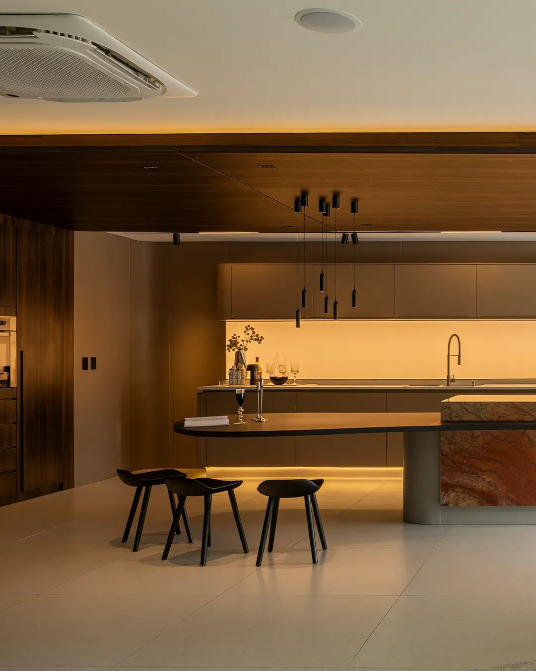 Cozinha planejada com ilha, mesa integrada e pendentes pretos